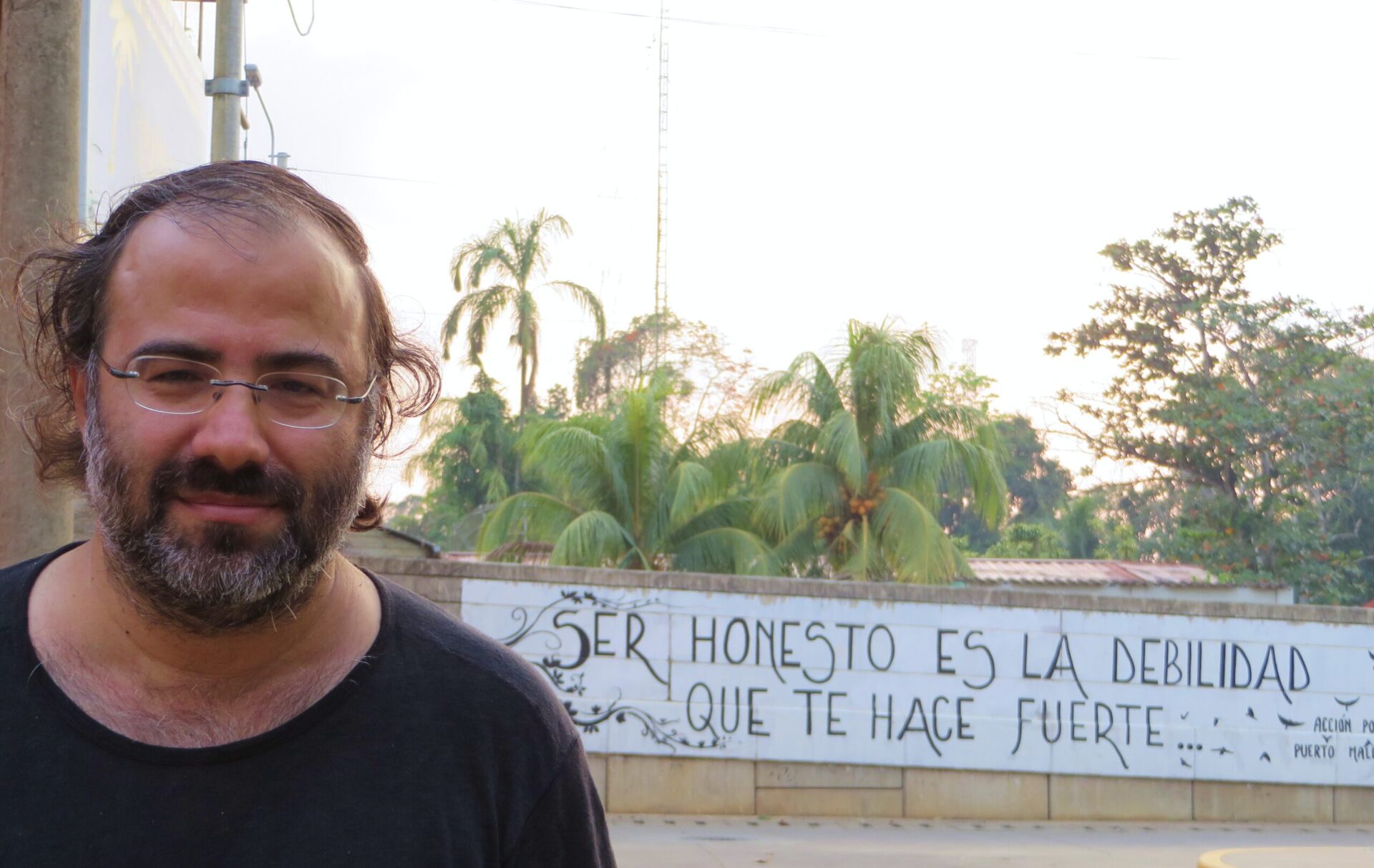 3 Alfredo Pérez Alencart en su ciudad natal(Puerto Maldonado, Perú), ante el mural que lleva un verso suyo