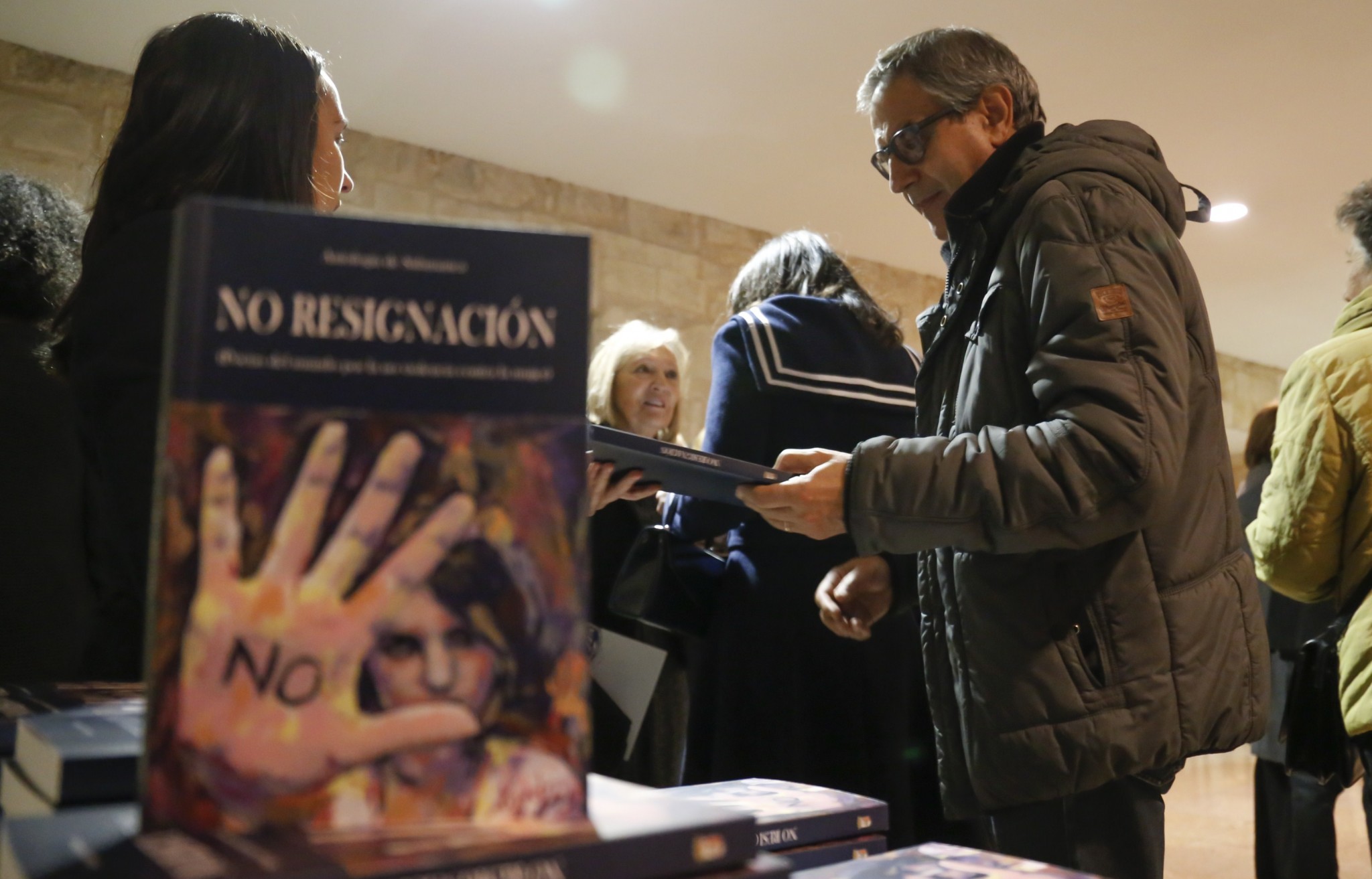 2-asistentes-pasando-por-la-mesa-con-ejemplares-de-la-antologia-de-salamanca-foto-m-laya