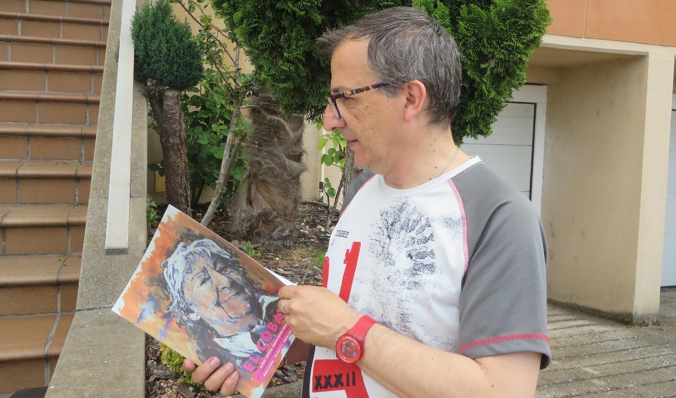 1 Miguel Elías, con la revista que lleva de portada el retrato que él hiciera de Gloria Fuertes